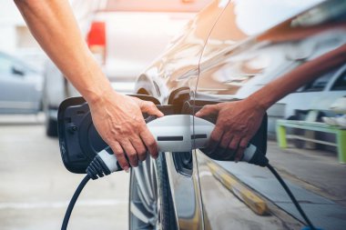 Sokakta modern elektrikli araba aküsünün şarj edilmesi. 