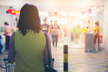 Kadın alışverişinin arka tarafı süpermarket koridoru ve raflarda profesyonel.