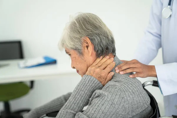 senior woman with neck pain in the medical office, Sick senior woman with back neck and shoulders pain on the joint and muscle.