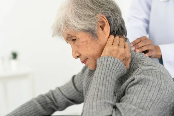 senior woman with neck pain in the medical office, Sick senior woman with back neck and shoulders pain on the joint and muscle.
