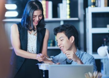 Gece geç saatlere kadar çalışan iş adamları, birlikte fazla mesai yapan iki genç iş adamı, dışarıdan yemek alıyor. 