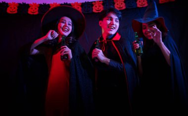 Kostümlü genç Taylandlılar Cadılar Bayramı 'nı kutluyor. Cadılar Bayramı kostümü giyen bir grup mutlu genç gece kulübünde Korkunç yüzler yaparak eğleniyor..