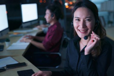 Taylandlı genç müşteri hizmetleri operatörleri gece vardiyasında çalışıyor.