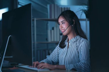 Taylandlı genç müşteri hizmetleri operatörleri gece vardiyasında çalışıyor.