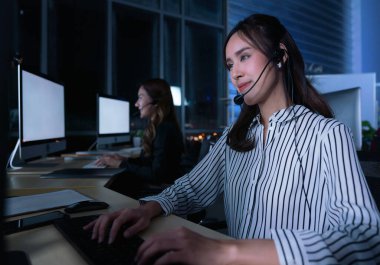 Taylandlı genç müşteri hizmetleri operatörleri gece vardiyasında çalışıyor.