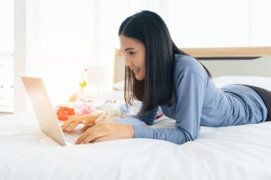 Bekar anne sabahları dizüstü bilgisayarla yatakta çalışmaya başlıyor. Ev konseptinden çalışmak, online alışveriş