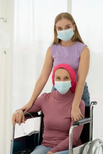 Hija Pequeña Abrazando Madre Enferma Que Usa Pañuelo Cabeza Silla — Foto de Stock