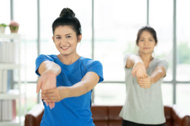 Genç, çekici, gülümseyen bir kadın yoga yapıyor spor kıyafetleri giyiyor, sakinleşiyor ve rahatlıyor. Kadın mutluluğu..