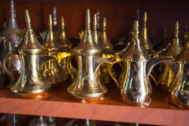 row of shiny traditional coffee pots and lamp at the souq in Dubai.