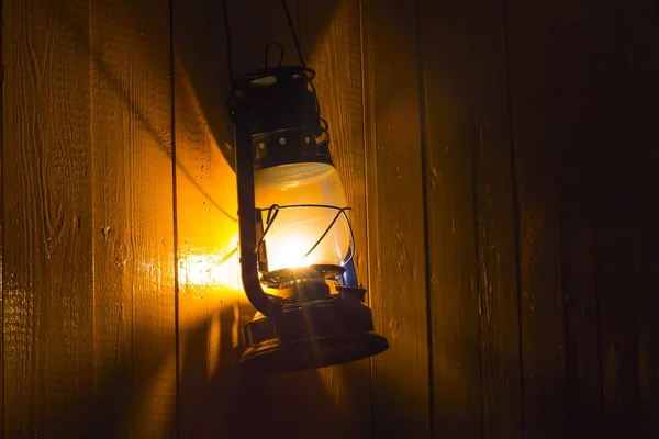 Vieja linterna de queroseno colgando de la pared de madera amarilla — Foto de Stock