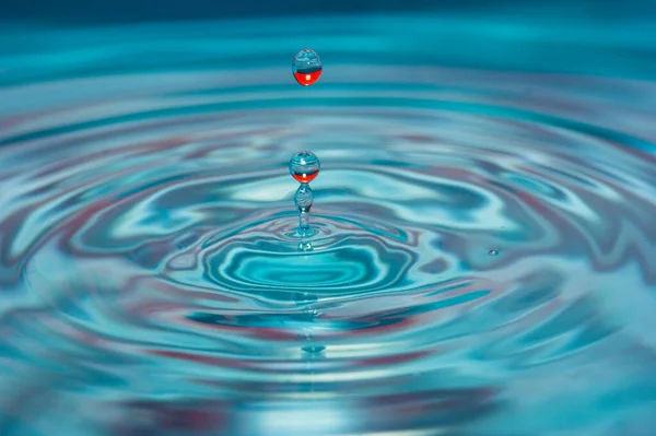 Water drop falling into water — Stock Photo, Image