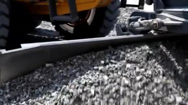 Sınıf öğrencisi Ekskavatör yolda ezilmiş taş yaymak