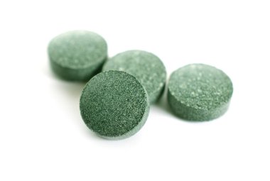 Arthrospira veya beyaz arka plan üzerinde izole spirulina ile tablet