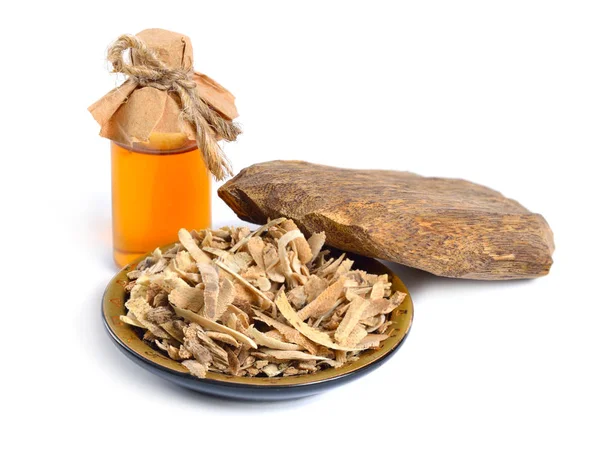 Agarwood, även kallad aloeswood oudh. Med eterisk olja i farmaceutiska flaska. Isolerad på vit bakgrund — Stockfoto