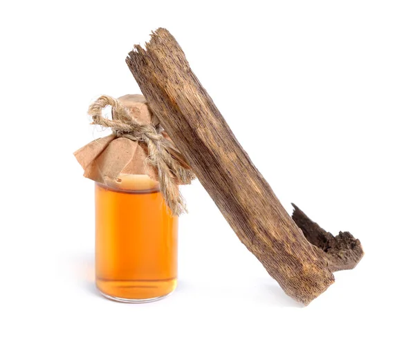 Agarwood, también llamado aloeswood oudh. Con aceite esencial en botella farmacéutica. Aislado sobre fondo blanco — Foto de Stock