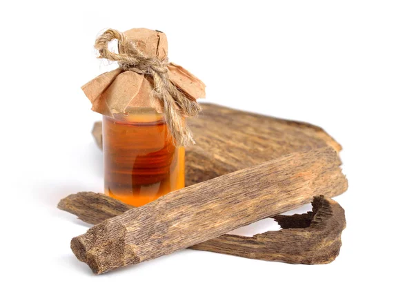 Agarwood, även kallad aloeswood oudh. Med eterisk olja i farmaceutiska flaska. Isolerad på vit bakgrund — Stockfoto