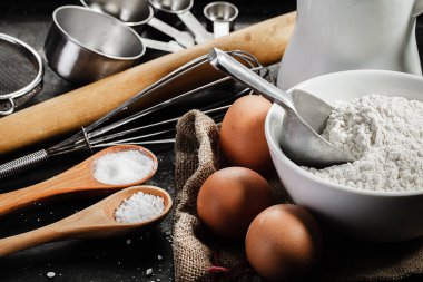 hamur malzemeleri ve mutfak gereçleri koyu arkaplanda