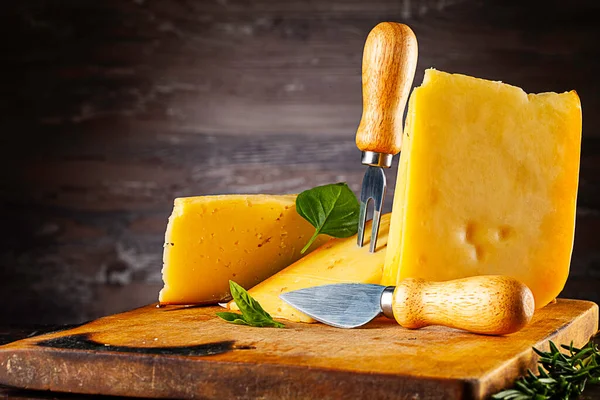 Peynirin Önü Yanmış Kesme Tahtasının Üzerinde Duruyor Arkaplanda Eski Ahşap — Stok fotoğraf