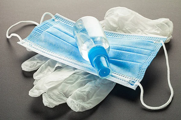Tıbbi maske, dezenfektan jeli, laboratuvar eldivenleri, haplar ve tabletler masanın üstünde. Virüs koruma ekipmanları.