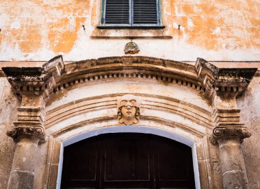 Gotik bir detay. Menorca 'nın Ciutadella kasabasındaki 200 yıllık bir binanın girişindeki genç kadın portresi.)