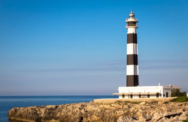MINORCA ISLE - SPAIN - CIRCA AĞUSTOS 2020: Günbatımında manzaralı Artrutx Deniz Feneri, Adanın ünlü simgesi