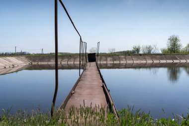 Mavi gökyüzü arka plan gölde eski, terk edilmiş, tahrip, paslı, köprüden 