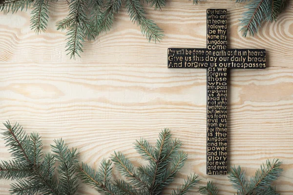 Croce di legno nera con la preghiera dei Signori sulla tavola di legno squallida con fondo di rami di abete — Foto Stock