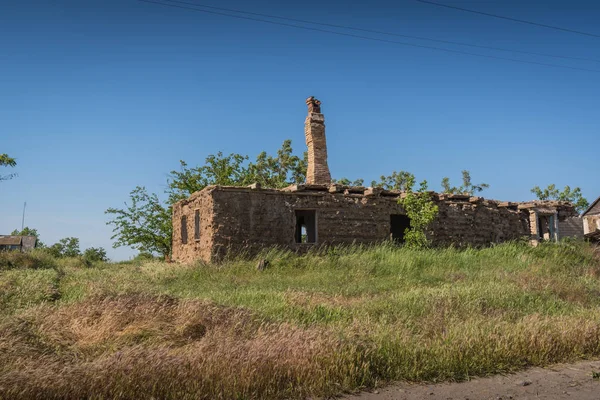 Maison abandonnée en ruine avec cheminée sur fond bleu ciel — Photo