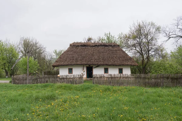 Hermoso paisaje. Cabaña tradicional ucraniana con un techo de lengüeta y una valla de madera — Foto de Stock