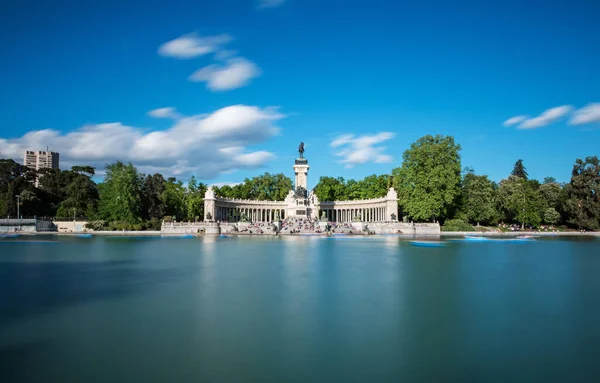 Madrid 'deki Retiro Park' taki (Parque del Buen Retiro) Alfonso XII anıtı için büyük bir gölet ve anıt. Uzun pozlama.
