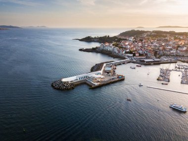 Aerial view of the lighthouse and harbour of Portonovo, a small village in the coast of Galicia, Spain, with the Cies and Ons islands in the background. clipart