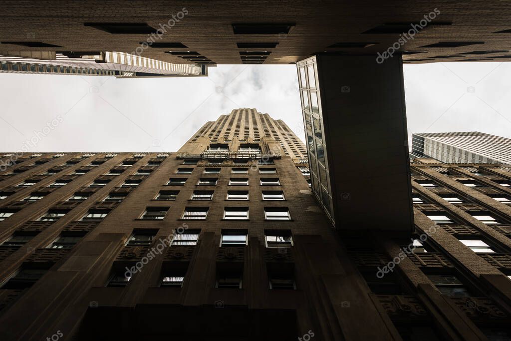 Low-angle view of a vintage office building in downtown Manhattan, with an elevated bridge connecting it to a neighbouring bank.