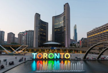 Toronto, Kanada - 6 Eylül 2015: Nathan Phillips Meydanı 'ndaki fıskiyenin aydınlatılmış belediye binası ve arka planda Özgürlük Kemerleri ile uzun gece pozu.