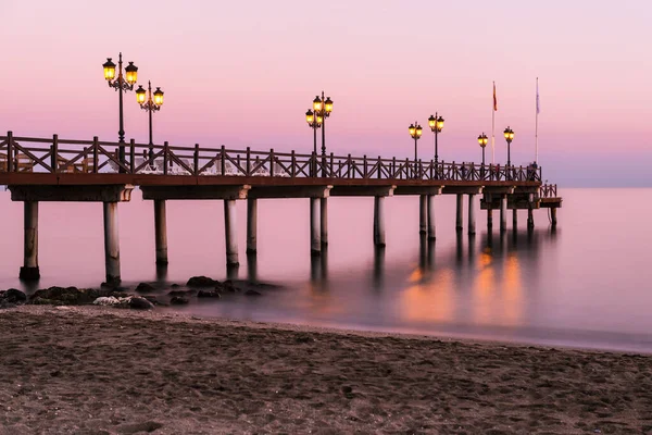 Beleuchteter Holzsteg Einem Strand Marbella Bei Sonnenuntergang Langzeitbelichtung — Stockfoto