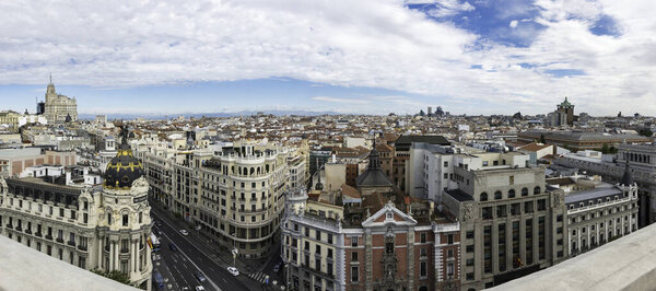 Panorama view of Gran Va and Madrids skyline on a cloudy Spring early morning, with the Metropolis building to be recognized in the foreground. Some other landmarks like the Telefonica skyscraper, Faro de Moncloa, Colon Tower or AZCA skyscrapers a