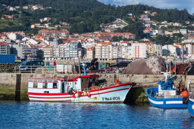 PORTONOVO, İspanya - 15 Ağustos 2020: Poronovo limanına demirlemiş renkli küçük balıkçı tekneleri alacakaranlıkta, Galiçya, İspanya.
