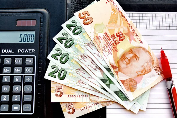 Siyah hesap makinesi arka planında 20 lira. Yakın çekim.