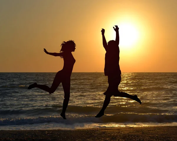 Силуэт Двух Друзей Прыгающих Пляже — стоковое фото