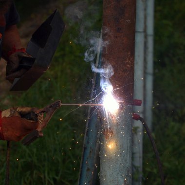 Eldiven ve kaynak maskesi ile kaynak ile bir adam kaynakçı 