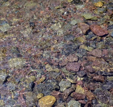 Su arka planı altında renkli çakıl taşları 