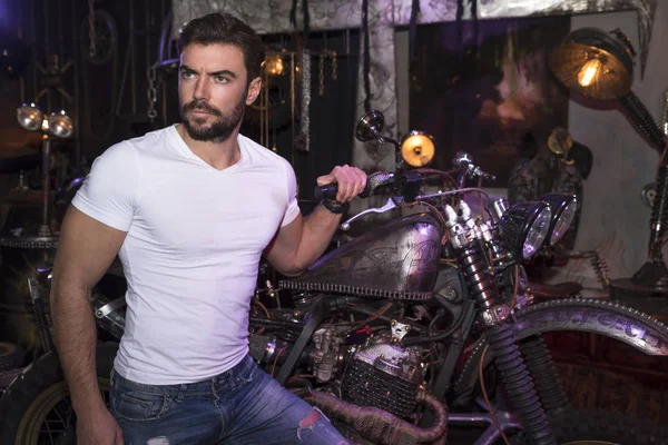 Motorcu moda kavramı. Kapalı poz zarif genç yakışıklı adam motorcu portresi.