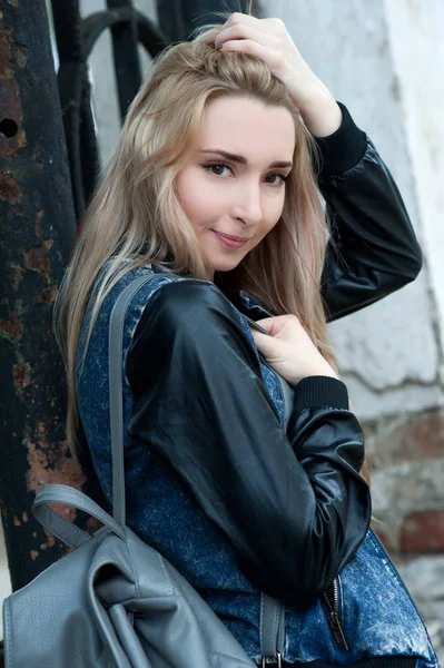 Beautiful sexy young blond woman in torn jeans posing on the streets of the old town