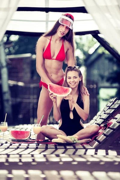 Two Beautiful Girls Swimsuits Posing Wooden Loungers Dish Fruits — Stock Photo, Image