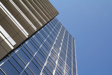 Gökyüzüne karşı modern bir ofis binasının cephesi.