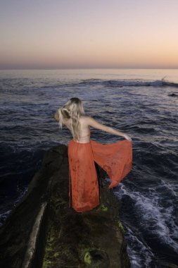 Sahil kayalar üzerinde güzel sarışın kadın