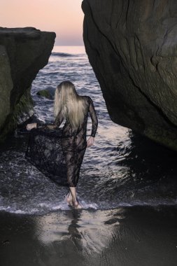 Sahil kayalar üzerinde güzel sarışın kadın