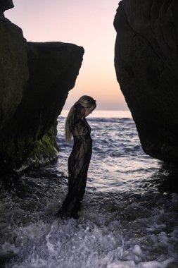 Sahil kayalar üzerinde güzel sarışın kadın