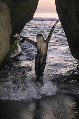 Sahil kayalar üzerinde güzel sarışın kadın