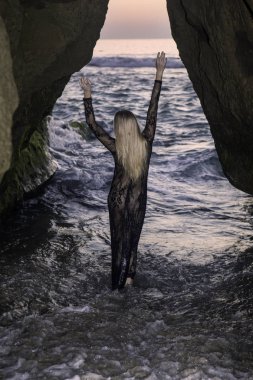 Sahil kayalar üzerinde güzel sarışın kadın