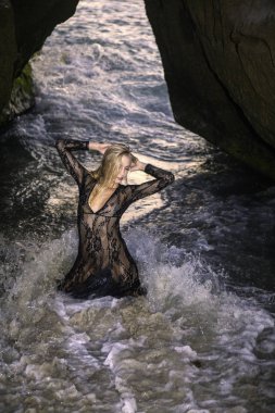 Sahil kayalar üzerinde güzel sarışın kadın